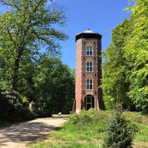 a tall brick tower sitting in the middle of a field at Vakantie op de Veluwe in Lunteren