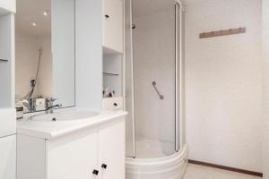 a white bathroom with a shower and a sink at Vakantie op de Veluwe in Lunteren +16 photos