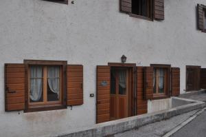 a building with wooden doors and windows on it at La Casa di Nicky - San Vito di Cadore in San Vito di Cadore
