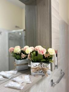 - une salle de bains avec 2 vases de fleurs sur un comptoir dans l'établissement Casa Mary, à Tropea