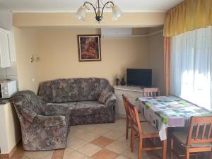 salon z kanapą i stołem w obiekcie Arany Apartmanház Zalagyöngye w Zalakaros