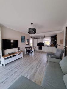 Televízia a/alebo spoločenská miestnosť v ubytovaní Apartament Sosnowy Las