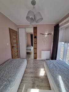 Posteľ alebo postele v izbe v ubytovaní Apartament Sosnowy Las