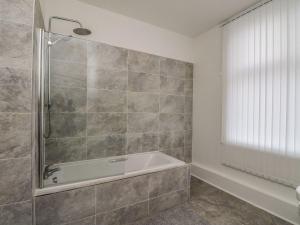 a bathroom with a shower and a bath tub at Annielea is a cosy 3 bed Cottage in Helensburgh in Helensburgh