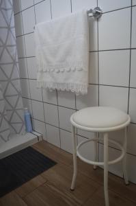a white bathroom with a stool and a towel at Casa do Marcelino Lagarto in São Roque do Pico +45 photos