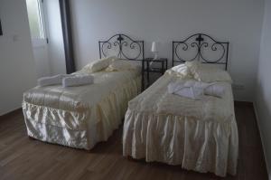 dos camas sentadas una al lado de la otra en un dormitorio en Casa do Marcelino Lagarto en São Roque do Pico