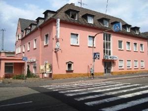 un gran edificio rosa en la esquina de una calle en Hotel Andernacher Hof, en Andernach