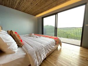 a bedroom with a large bed and a large window at The Skyview Hòa Bình in Kệ Sơn