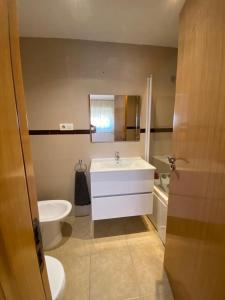 ein Badezimmer mit einem weißen Waschbecken und einem WC in der Unterkunft Valparaiso Marina Dór Planta 7 in Oropesa del Mar