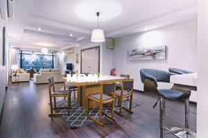 uma sala de jantar e sala de estar com mesa e cadeiras em AA Residen Luxury Condo HOMESTAY 18mins walk Tanjung Aru Beach & GOLF Course, not Beach Side Resort em Kota Kinabalu