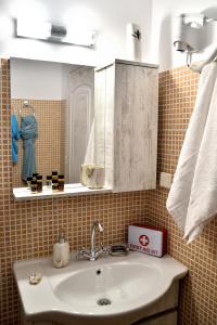 a bathroom with a sink and a mirror at PLUMERIA HOUSE in Archangelos