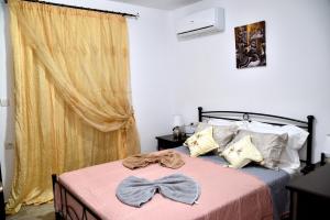 a bedroom with a bed with a bow tie on it at PLUMERIA HOUSE in Archangelos