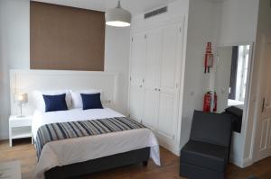 um quarto com uma cama com almofadas azuis e uma cadeira em Edificio Charles 101 no Funchal