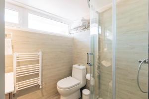 a bathroom with a toilet and a glass shower at Casablu Hotel in Valparaíso +124 photos