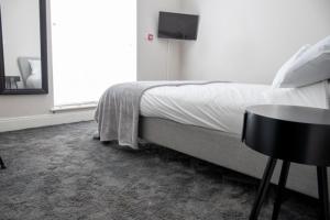 Schlafzimmer mit einem Bett, einem Tisch und einem Fenster in der Unterkunft Withnell Stays - Apartment One - Ground Floor in Blackpool