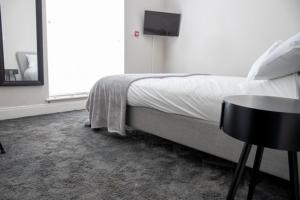 ブラックプールにあるWithnell Stays - Apartment One - Ground Floor - Retro Gaming Machineのベッドとテーブルと窓のある寝室