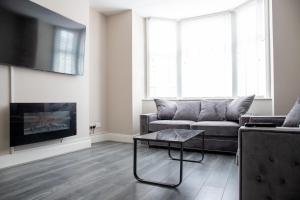 ein Wohnzimmer mit einem Sofa und einem Couchtisch in der Unterkunft Withnell Stays - Apartment One - Ground Floor in Blackpool