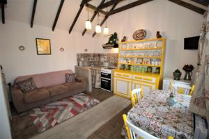 Geraghtys Farmyard Pods في مايو: مطبخ وغرفة معيشة مع أريكة وطاولة