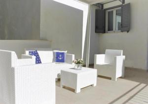 a living room with white chairs and a table at Casa Vacanze " ORTE " in Otranto