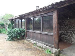 a building with windows and a stone wall at Casa de Campos in Silleda