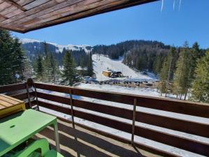 a balcony with a table and a view of a ski slope at Apartman Luka in Jahorina