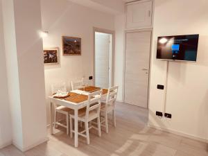 ヴェローナにあるGrazia Luxury Homeのダイニングルーム(テーブル、椅子、テレビ付)