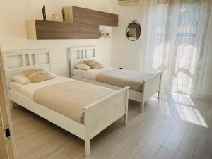 ヴェローナにあるGrazia Luxury Homeのベッドルーム1室(ベッド2台、壁掛け鏡付)