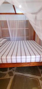 Bett in einem Zimmer mit Moskitonetz in der Unterkunft PWANI HOUSE cottage in Watamu