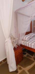 מיטה או מיטות קומותיים בחדר ב-PWANI HOUSE cottage