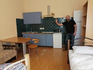 Ein Mann steht in der Küche einer Wohnung in der Unterkunft Freedom in Uschhorod