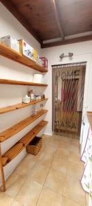 una stanza con scaffali in legno e una porta con un cancello di Villa Harmony a Charco del Palo