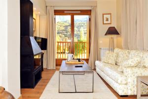 a living room with a couch and a table at Chardín de Llum-Apartamentos Chardins in Benasque