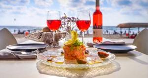 - une table avec une assiette de nourriture et des verres à vin sur la plage dans l'établissement Beachfront Apartment Bat Yam 613, à Bat Yam