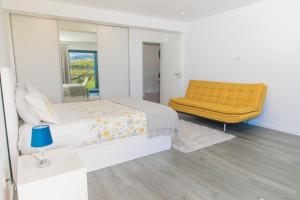 una camera con letto giallo e specchio di House - sleeps 3 free parking garden & jacuzzi a Estreito da Calheta
