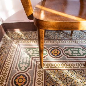 a wooden chair sitting on a floor with a rug at Casa Anna in Lucca