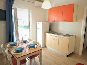 a kitchen with a wooden table and a kitchen with a dining room at Apartman Nina in Gradac