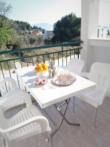 a white table with plates of food on a balcony at Apartman Nina in Gradac