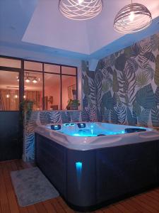 a large bath tub with blue lights in a room at L'Entracte et son spa privatif in Esquelbecq