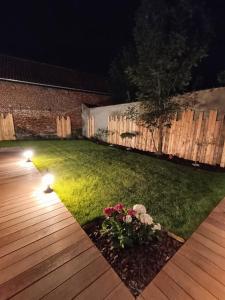 einen Garten in der Nacht mit Lichtern auf dem Rasen in der Unterkunft L'Entracte et son spa privatif in Esquelbecq