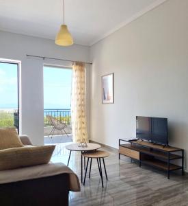 - un salon avec un canapé et une télévision dans l'établissement Almyros Aktis seaview apartment, à Kalamata