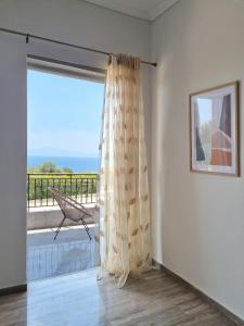 Cette chambre dispose d'une porte coulissante en verre offrant une vue sur l'océan. dans l'établissement Almyros Aktis seaview apartment, à Kalamata