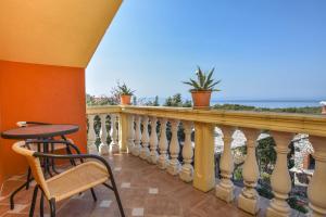 a balcony with a table and a chair at House Luce in Neviđane