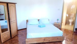 ein Schlafzimmer mit einem Bett und ein Badezimmer mit einem WC in der Unterkunft Le Shanoa in Rodrigues Island