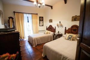 een slaapkamer met 2 bedden, een dressoir en een raam bij LA CASONA OLIVENTINA in Olivenza