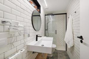 une salle de bain blanche avec un lavabo et un miroir dans l'établissement Santo Andía by Clabao, à Pampelune 10 autres photos