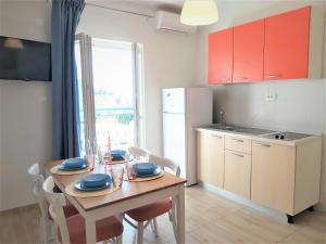 a kitchen with a wooden table with chairs and a table and a dining room at Apartman Nina in Gradac