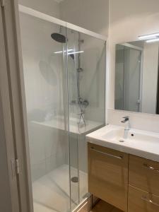 uma casa de banho com uma cabina de duche em vidro e um lavatório. em DECOUVERTE DE MARSEILLE em Marselha