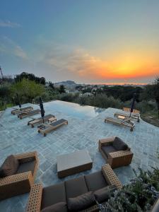 a patio with chairs and a pool with a sunset at Torre Scribanti in Sestri Levante
