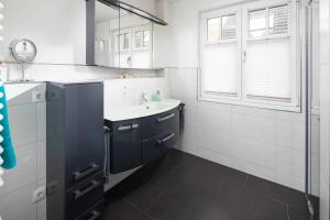 a white kitchen with a sink and a mirror at Utspann in Norderney