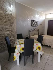 comedor con mesa, sillas y cama en Appartamenti San Vito, en San Vito